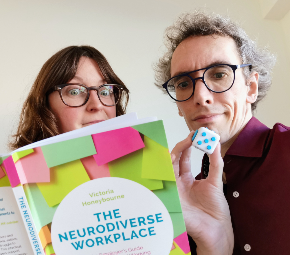 Daphné and Dietrich with a book on neurodiversity in the workplace and a fidget cube.