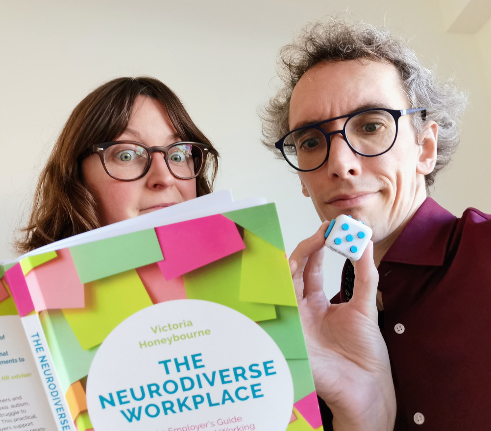 Daphné et Dietrich avec un livre sur la neurodiversité au travail et un fidget cube.